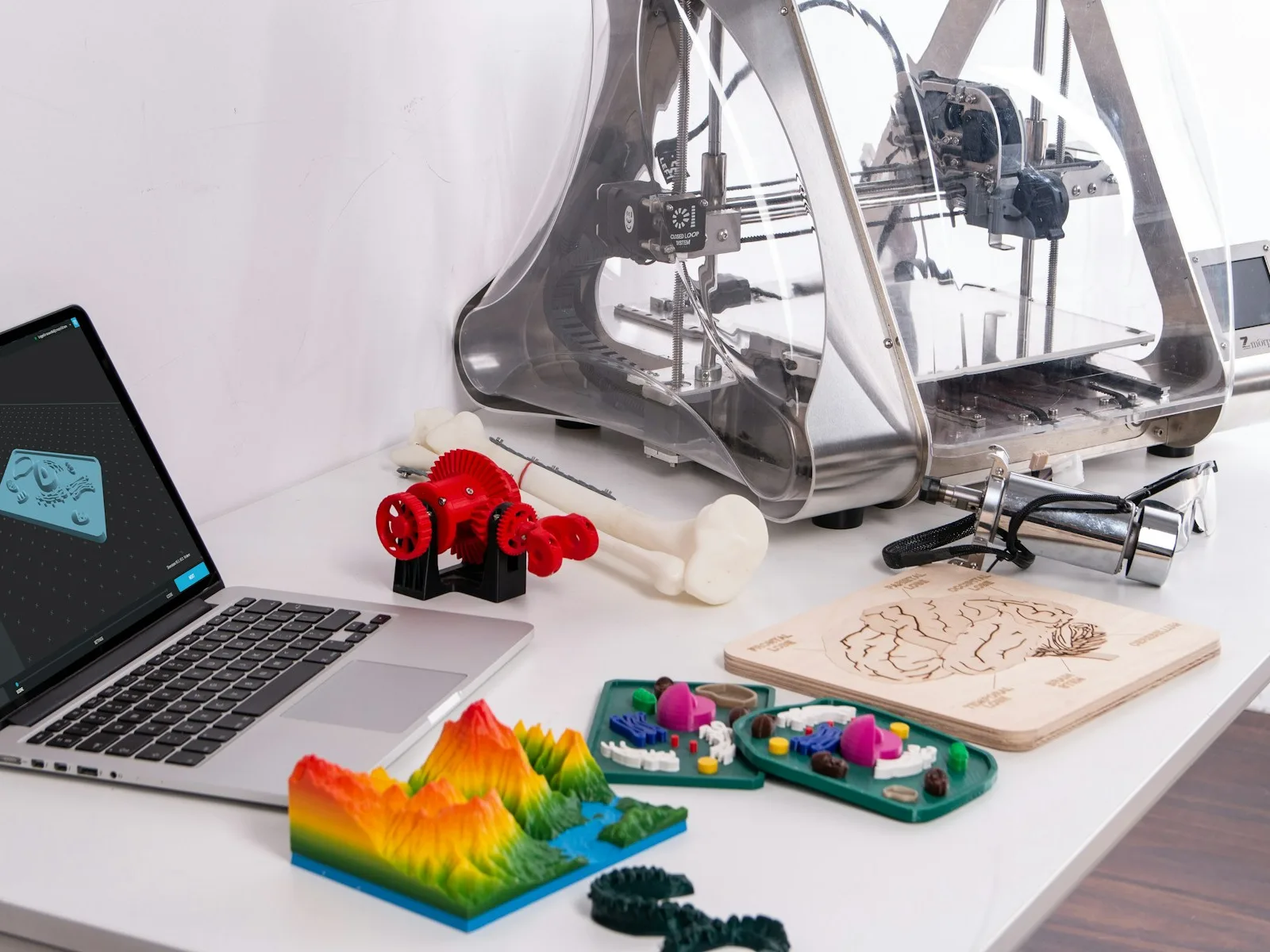 Digitale Modellierung und unterschiedlich ausgeführte Bauteile an einem 3D-Drucker.