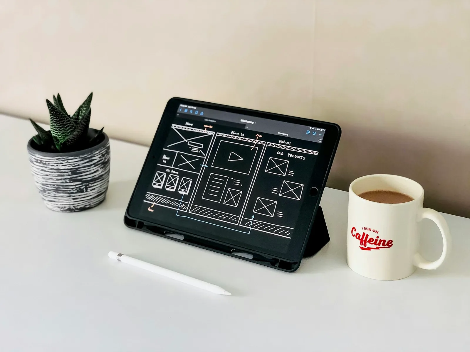 Tablet mit skizzierten Seitenaufbauten und Navigation auf einem Schreibtisch.