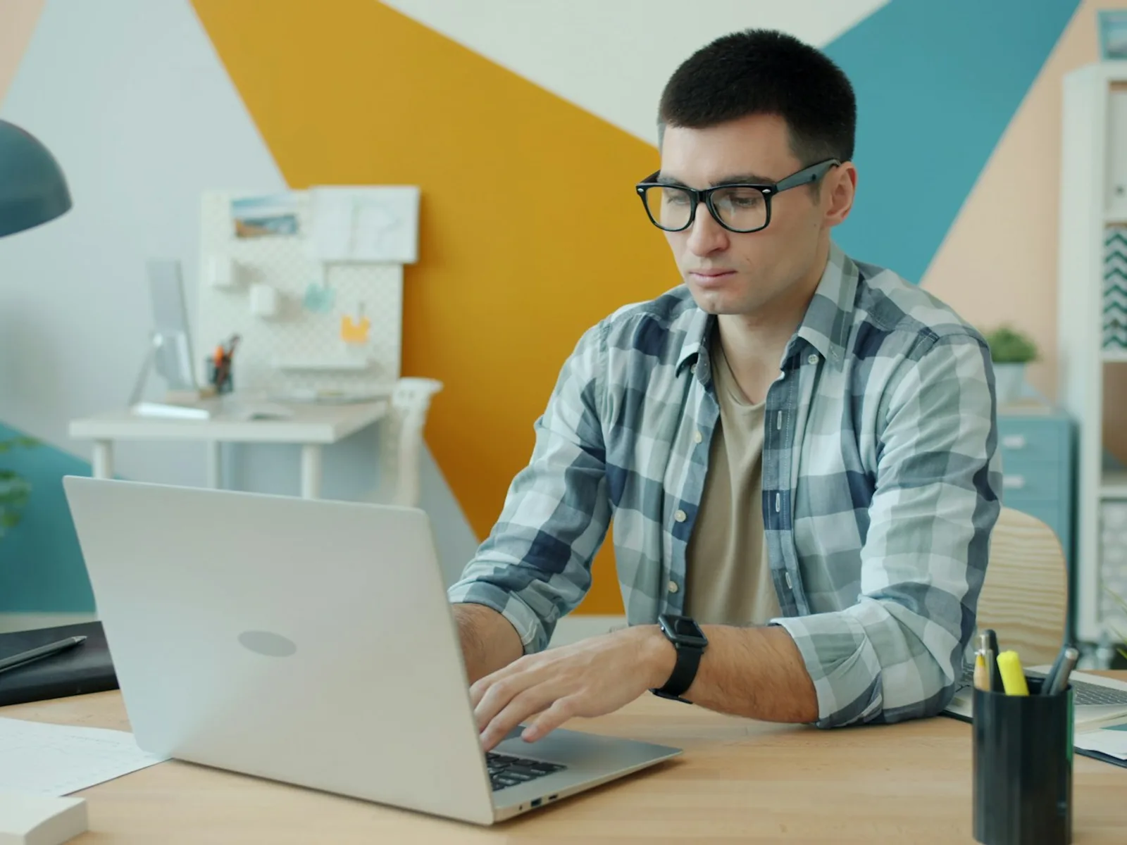 Person arbeitet konzentriert an einer Anwendung auf einem Laptop.