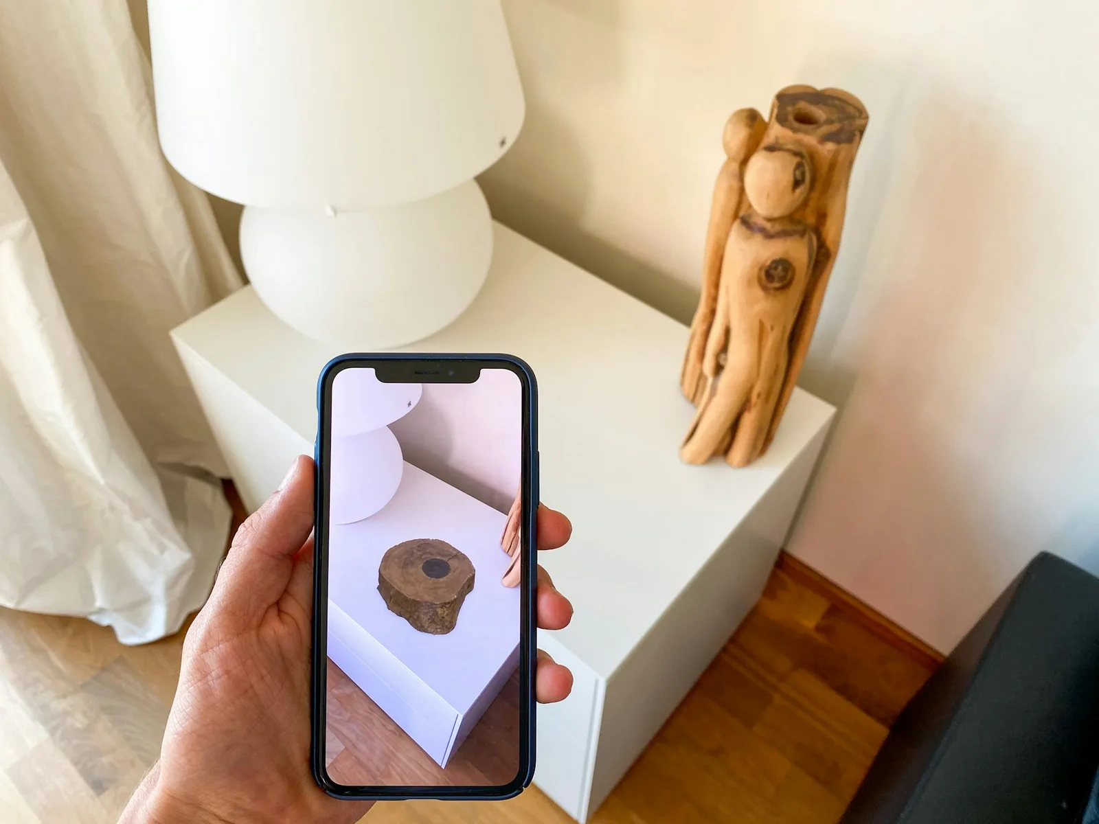 Smartphone zeigt ein räumlich platziertes Objekt auf einem Tisch im Kamerabild.