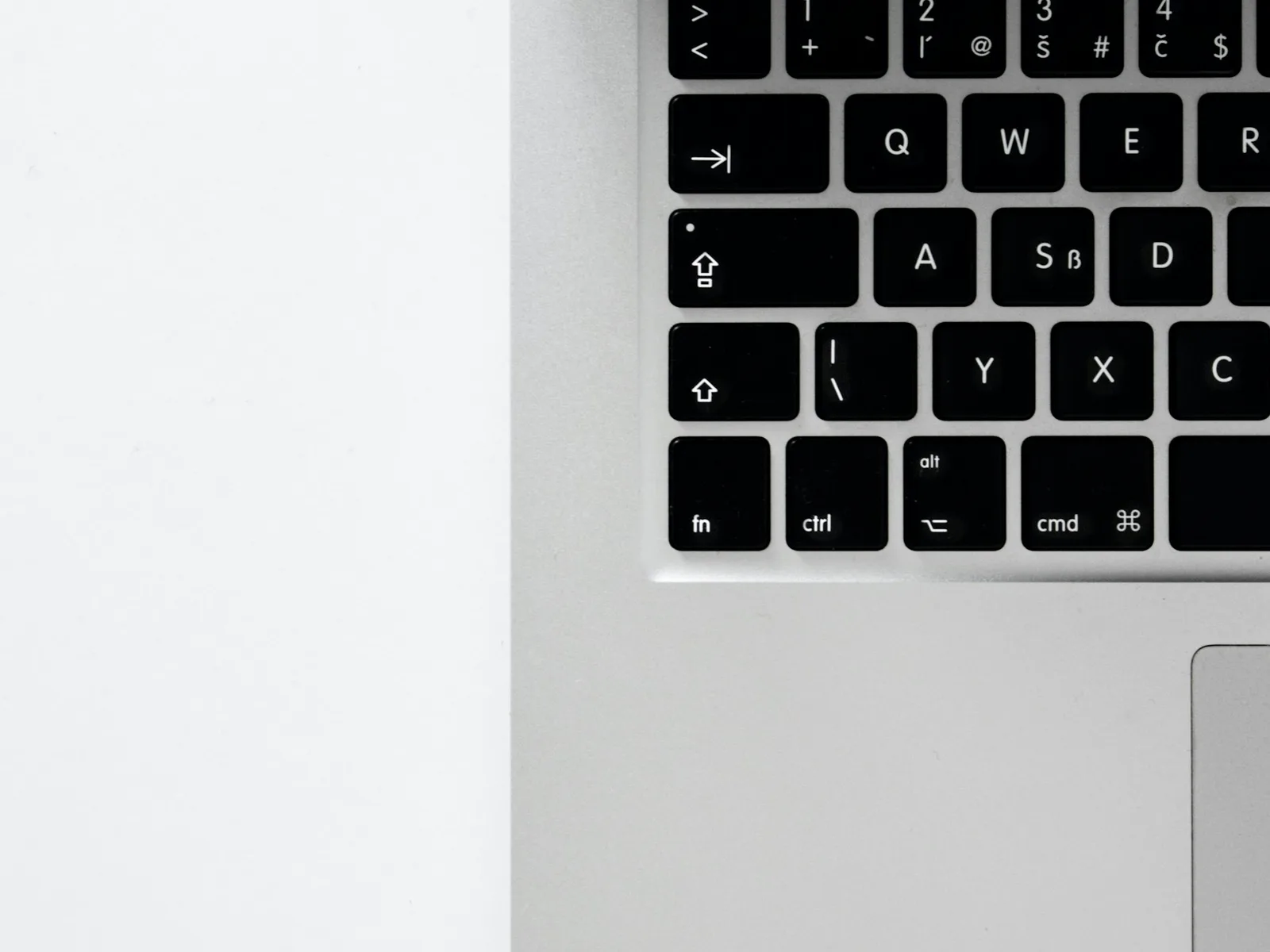 Close-up of a laptop keyboard with navigation keys beside a trackpad.