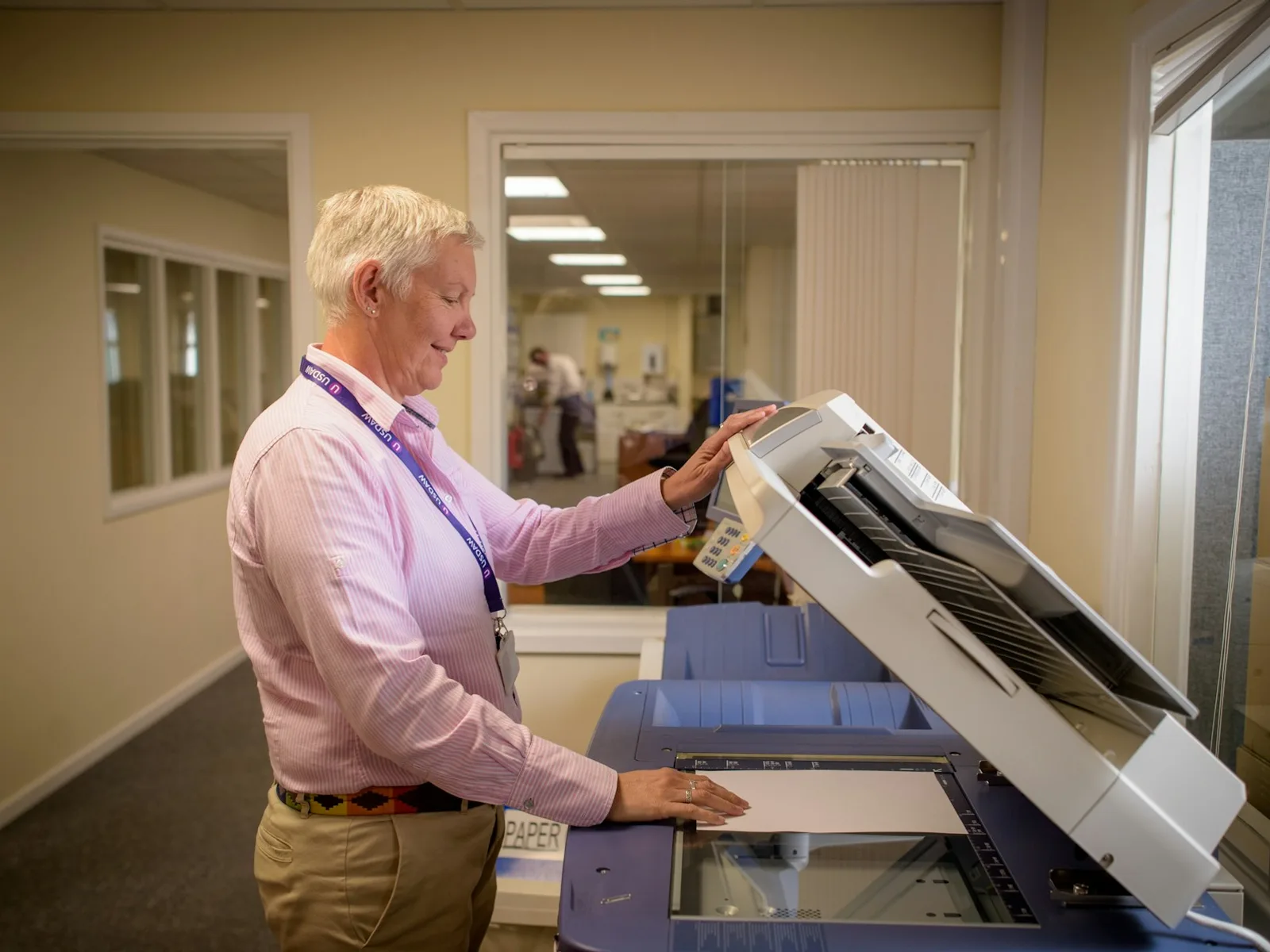 Person legt ein Dokument auf die Glasfläche eines Scanners.
