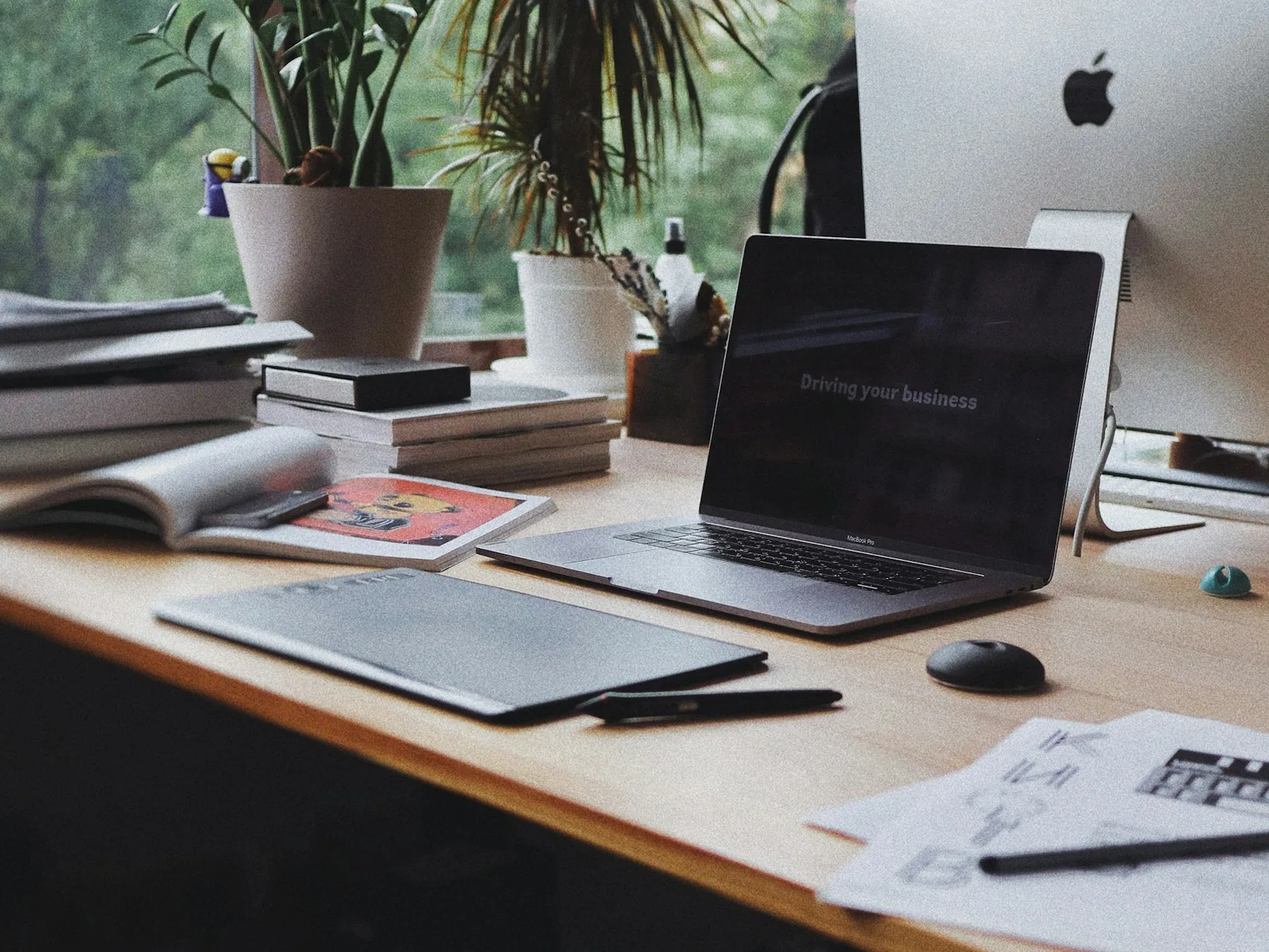 Arbeitsplatz mit Laptop, großem Bildschirm und Eingabegeräten.