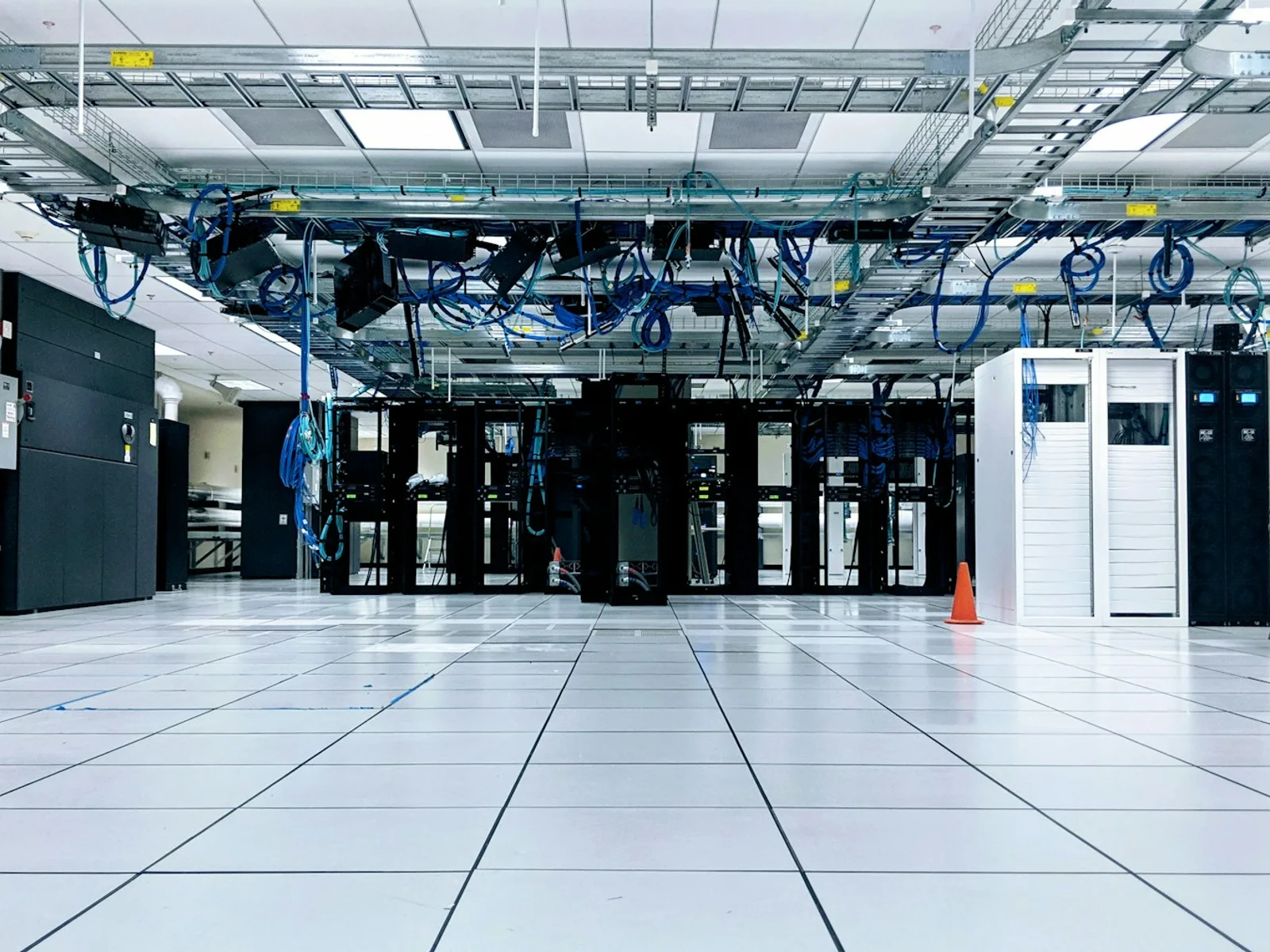 Serverraum mit geordneten Racks, Leitungen und technischen Anlagen.
