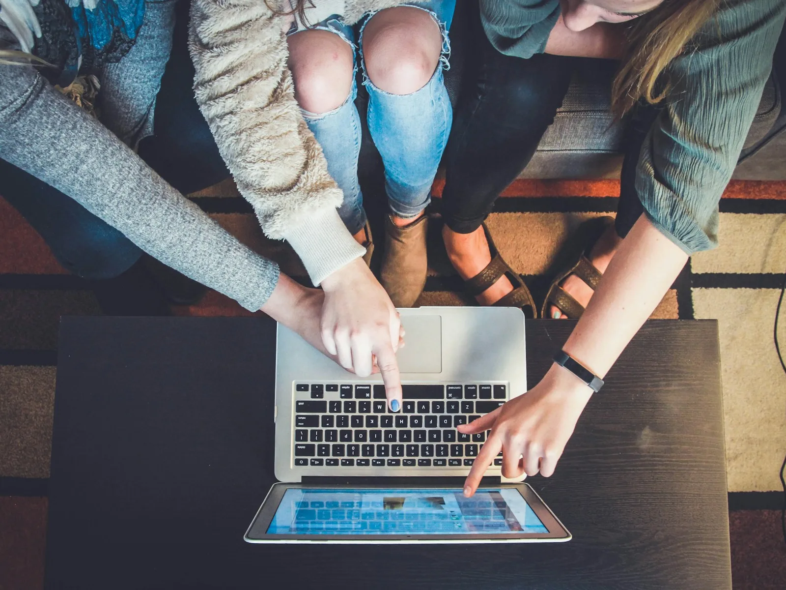 Mehrere Personen betrachten gemeinsam eine Website auf einem Laptop.