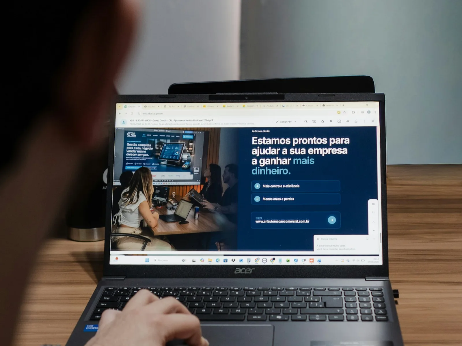 Person prüft eine Website mit Texten, Bild und Kontaktmöglichkeit auf dem Laptop.