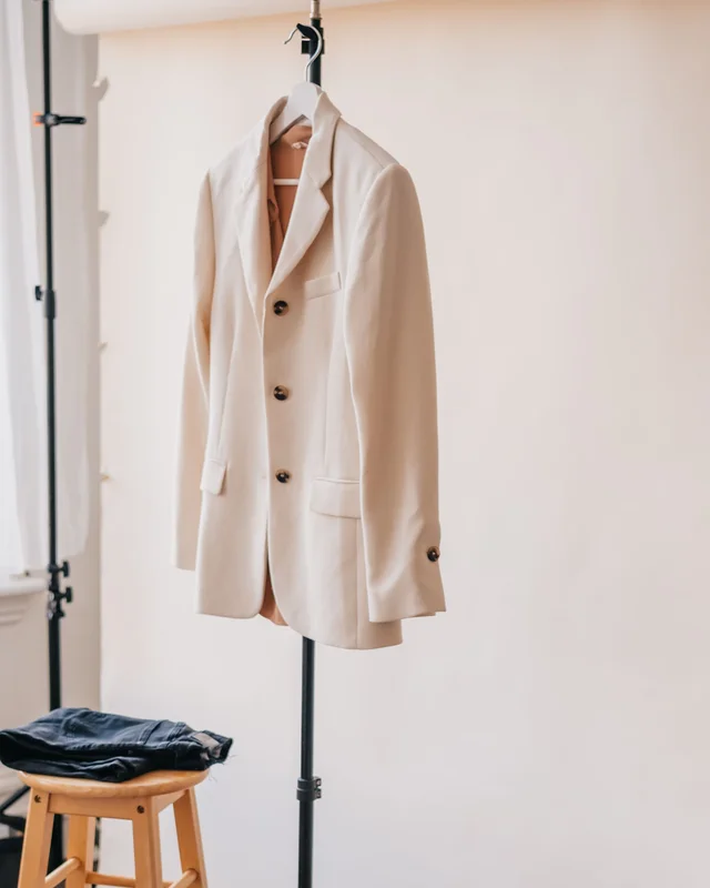 Heller Blazer auf einem Kleiderbügel im fiktiven Produktbeispiel